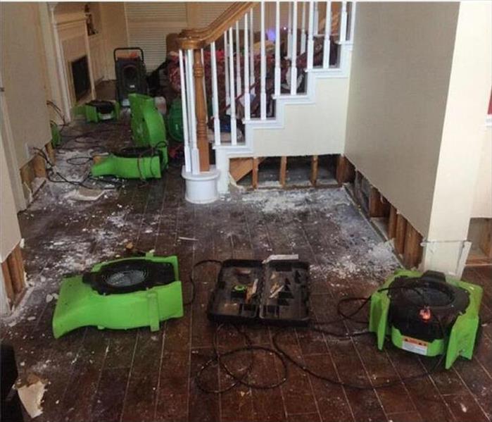 air mover and dehumidifiers drying storm damaged home
