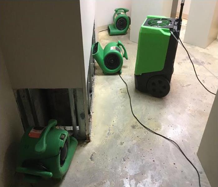 air mover and dehumidifiers drying water damaged home